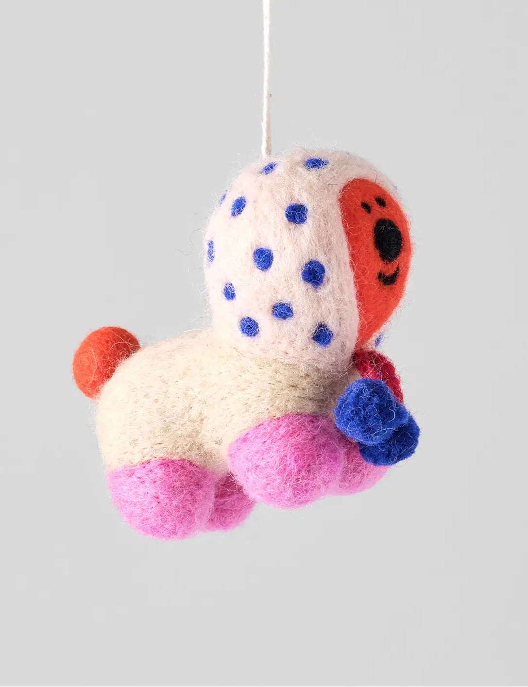 Wrap felt Pom Pom kerstornament: crèmegekleurd dier met blauwe stippen, een rood gezicht en roze pom-pom-pootjes.