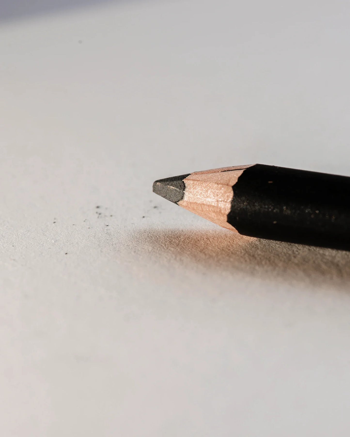 Close-up van een geslepen potlood op een lege pagina, ideaal voor gebruik met een schetsboek.