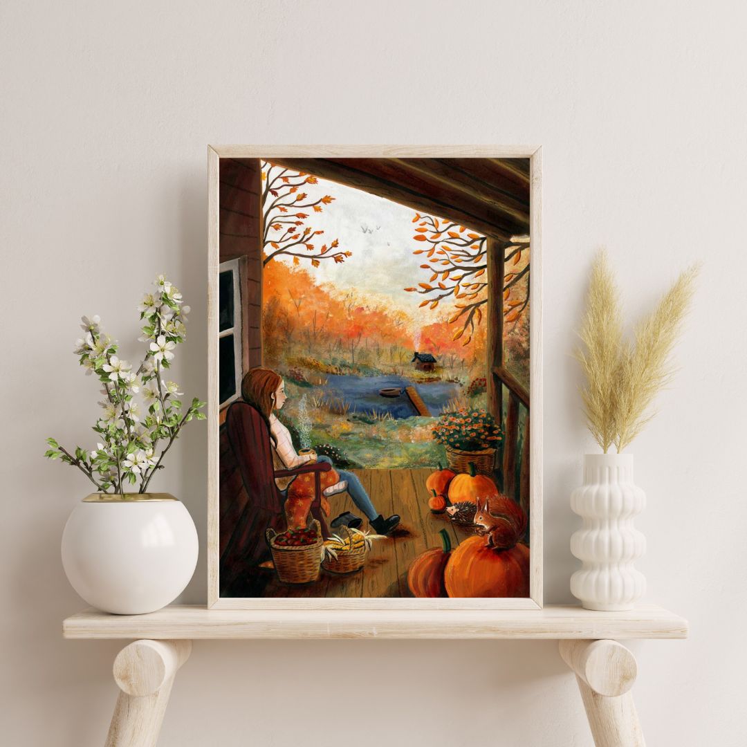 Cozy autumn art print by Esther Bennink: woman on a porch with pumpkins and golden trees in warm orange tones.