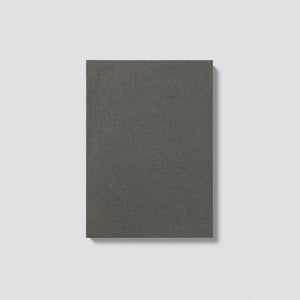 Getextureerd leigrijs mishmash Naked A5 notitieboek met een minimalistisch omslagontwerp op een strakke grijze studio-achtergrond.